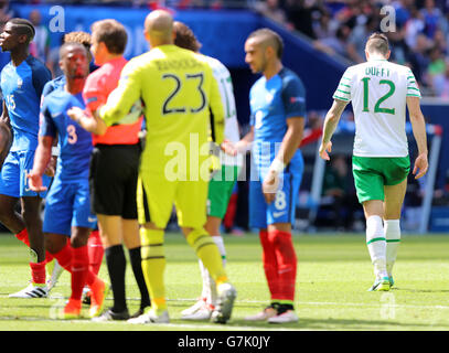 Republic of Ireland's Shane Duffy (right) leaves the field after being shown a red card for a doul on France's Antoine Griezmann (not pictured) during the round of 16 match at the Stade de Lyon, Lyon. Stock Photo