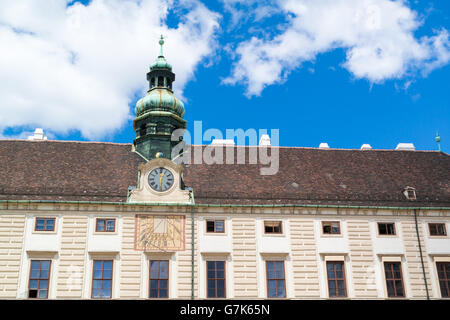 Top facade of Amalienburg with tower dome, clock and sundial, part of Hofburg Imperial Palace in Vienna, Austria Stock Photo