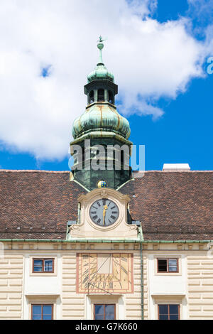 Top facade of Amalienburg with tower dome, clock and sundial, part of Hofburg Imperial Palace in Vienna, Austria Stock Photo