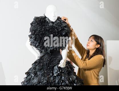 Angela Tye adjusts a Gareth Pugh dress worn by Lady Gaga, which is made out of shredded black bin bags, part of the 'Women Fashion Power' exhibition at the Design Museum, London, which examines how influential women in politics, business and popular culture have used and influenced fashion. Stock Photo