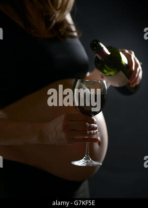 An eight month pregnant woman holds a glass of wine, London. Stock Photo