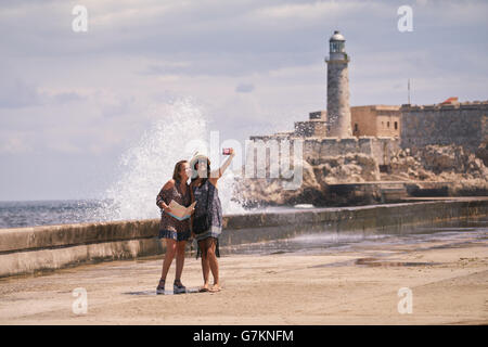 Female friends on holiday, young women taking selfie with mobile phone in Havana, Cuba. Stock Photo