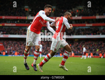 Arsenal's Theo Walcott (right) celebrates scoring his side's third goal with team-mate Olivier Giroud during the Barclays Premier League match at the Emirates Stadium, London. Stock Photo