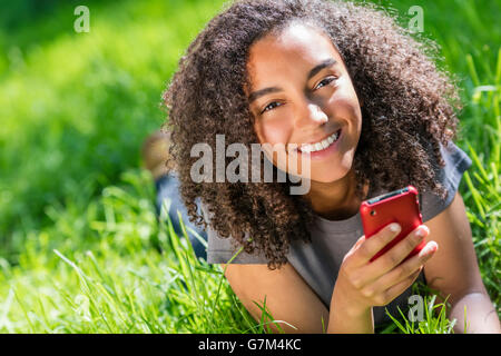 Outdoor portrait of beautiful happy mixed race African American girl teenager female young woman smiling with perfect teeth text Stock Photo