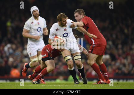 England's Chris Robshaw (centre) is tackled by Wales' Samson Lee (left) and Gethin Jenkins (right) during the RBS 6 Nations match at the Millennium Stadium, Cardiff. Stock Photo