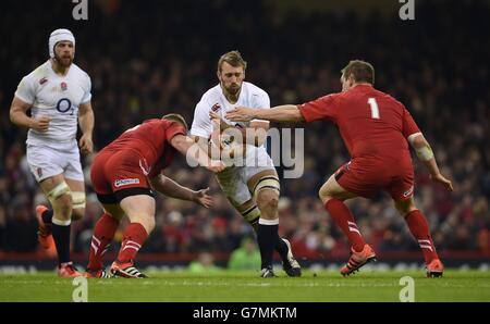 England's Chris Robshaw (centre) is tackled by Wales' Samson Lee (left) and Gethin Jenkins (right) during the RBS 6 Nations match at the Millennium Stadium, Cardiff. Stock Photo