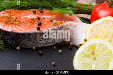 red fish steak with spices on a slate plate. Stock Photo
