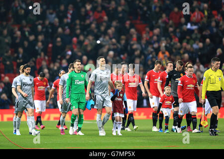 Manchester United and Burnley players walk out onto the pitch for the ...