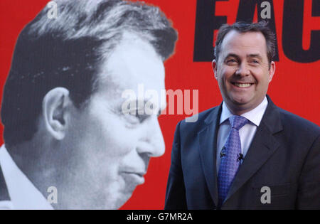 Liam Fox, the Conservative Party co-chairman, infront of a poster showing the infighting within the Labour Party. Stock Photo