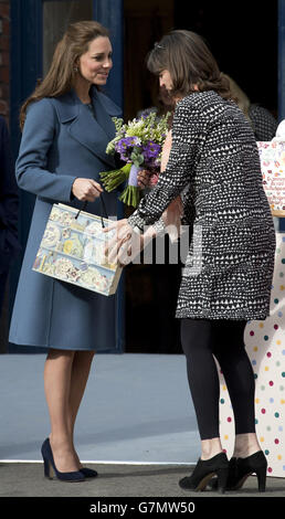 The Duchess of Cambridge smiles as she receives flowers from Emma Bridgewater during a during a visit to the Emma Bridgewater factory in Stoke-on-Trent, Staffordshire, to see production of a mug the company has launched in support of East Anglia's Children's Hospices. Stock Photo