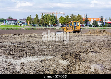 Earthmover with caterpillar is moving earth outdoors. Stock Photo