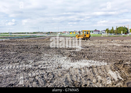 Earthmover with caterpillar is moving earth outdoors. Stock Photo