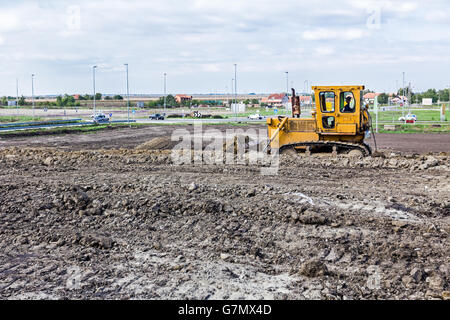 Earthmover with caterpillar is moving earth outdoors. Stock Photo