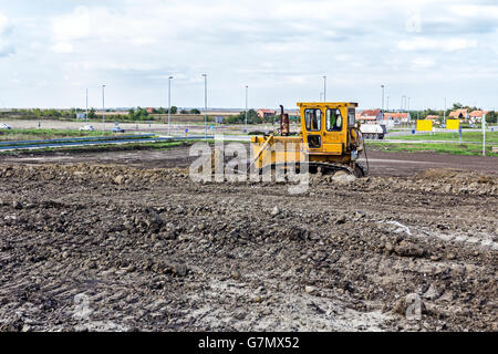 Earthmover with caterpillar is moving earth outdoors. Stock Photo