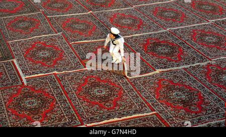 A young female Sailor lays back one of the hundreds of Carpets laid for the Prince of Wales' car to drive on, before he boards HMS Dauntless for a tour of the vessel which is docked in Kuwait City, on the third day of his tour to the middle east. Stock Photo