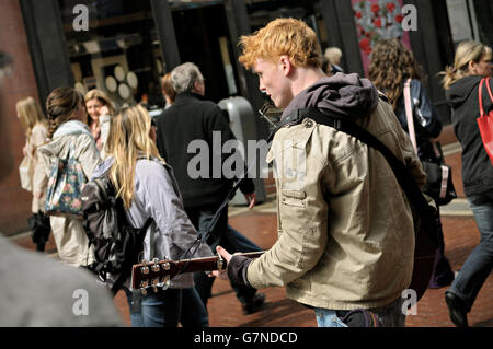 Street musician playing guitar and harmonica in Grafton Street in the city centre of Dublin, Ireland Stock Photo