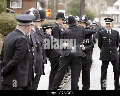 PC Robert Brown is hugged by colleagues at Croydon Police Station in south London. The country's longest-serving officer is retiring after 47 years of service, he was greeted by a guard of honour by colleagues, including officers from Croydon and the Met's dog unit. Stock Photo