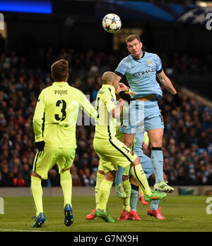 Manchester City's Edin Dzeko (right) has a headed attempt on goal during the UEFA Champions League, Round of 16 match at the Etihad Stadium, Manchester. Stock Photo