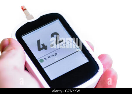 Blood glucose monitor showing a glucose level of 4.2mmol/L, within the normal range of 4.0 to 5.9 mmol/L under normal conditions Stock Photo