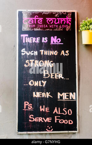 Sign outside Cafe Munk, Copenhagen, saying 'There is no such thing as strong beer, only weak men. PS We also serve food'. Stock Photo