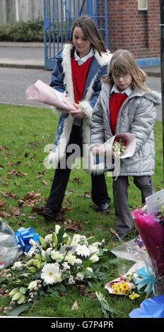 Young children lay bunches of flowers in remembrance of the Hercules air crash in Iraq outside the main entrance at RAF Lyneham. Stock Photo