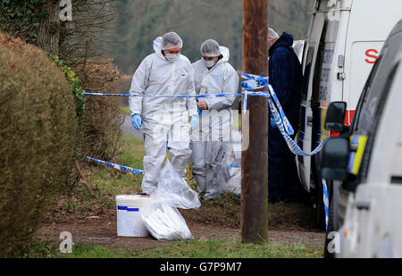 Crime scene investigators continue their work at the scene in Ifield, Sussex, following the discovery by fire fighters of a body inside a burning car last Friday afternoon. Stock Photo