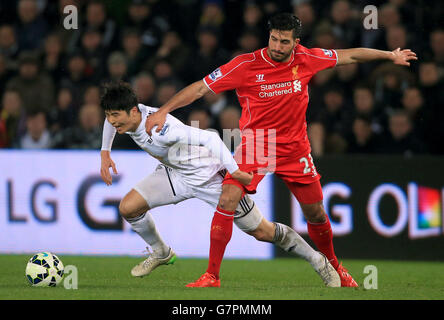 Soccer - Barclays Premier League - Swansea City v Liverpool - Liberty Stadium. Swansea City's Ki Sung-Yueng is fouled by Liverpool's Emre Can Stock Photo