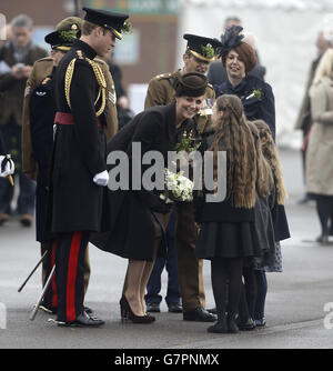 The Duke and Duchess of Cambridge talk to Company Sgt Major Flynn's 8-year-old daughter Ciara and her 6-year-old twin sisters Eva and Leah, as they visit members of the 1st Battalion Irish Guards at the St. Patrick's Day Parade at Mons Barracks, Aldershot, Hampshire, to mark St Patrick's Day today. Stock Photo