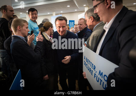 Prime Minister David Cameron walks past party members at a campaign event at the Dhamecha Lohana Centre in Harrow, north London. Stock Photo