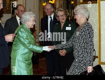 Queen Elizabeth II meets Dame Mary Peters (right) as she hosts the Winston Churchill Memorial Trust Reception at Buckingham Palace, London. Stock Photo