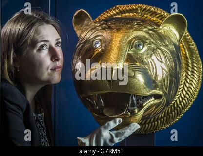 Exhibition Curator Lauren Porter with a golden Tiger's head which was part of the throne of Tipu Sultan (1750-99), ruler of Mysore, India, which forms part of the Gold exhibition at the The Queen's Gallery at the Palace of Holyroodhouse in Edinburgh. Stock Photo