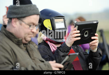 A member of the public takes a picture on her iPad as she wears a welding mask to watch a partial eclipse of the sun, at Stonehenge in Wiltshire. Stock Photo