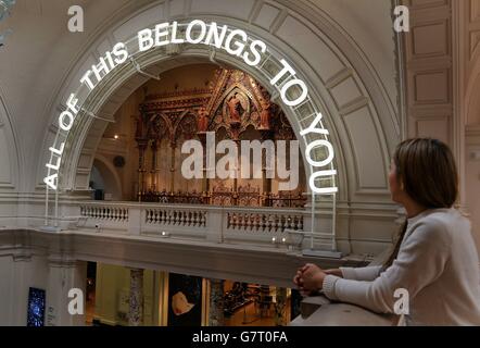 A neon sign hangs above the inside of the main entrance to the Victoria & Albert Museum, where the 'All Of This Belongs To You' exhibition' opens to the public on 1st April, in London. Stock Photo