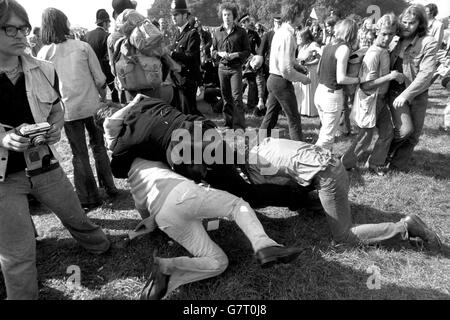 A policeman wrestling with a man on the ground as the free pop festival in Windsor Great Park ended in scuffles today. Police were dispersing groups of fans still at the site after a swoop by over 600 policeman had broken up the festival. Stock Photo