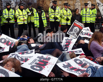 Dozens of anti-war protesters taking part in a mass 'die-in' outside Parliament. The protestors are calling for British troops to be withdrawn from Iraq. Chanting slogans and holding banners, the activists blocked two lanes of the road during the event organised by the Stop The War Coalition and CND. Stock Photo