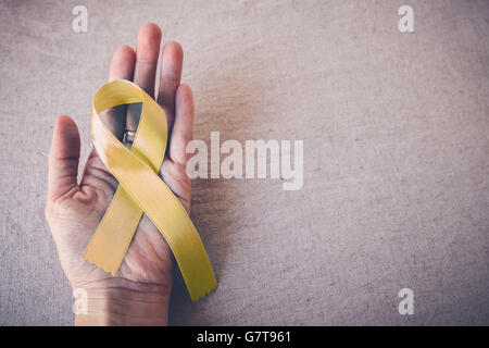 Yellow Ribbon Cancer Awareness On Wooden Background Stock Photo - Alamy