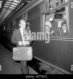 Christopher Chataway, Joint Parliamentary Under-Secretary of State, Ministry of Education and Science, goes to board a train at Paddington Station in London. Labour Party leader Harold Wilson can be seen aboard the train, setting off for Cardiff to begin his General Election tour. Stock Photo