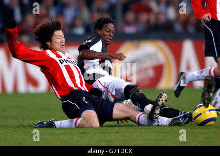 Soccer - UEFA Champions League - Round of 16 - First Leg - PSV EIndhoven v Monaco - Philips Stadium. PSV Eindhoven's Ji-Sung Park (l) and Monaco's Mohamed Kallon battle for the ball Stock Photo