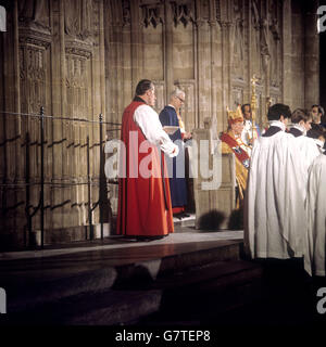 Dr. Donald Coggan is seated in the St. Augustine's Chair above the nave steps during his enthronement service as Archbishop of Canterbury, Primate of All England, at Canterbury Cathedral. Choristers go in procession down the steps, followed by other clergy. Stock Photo