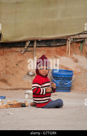 Indian little girl playing on ground in the street. Stock Photo