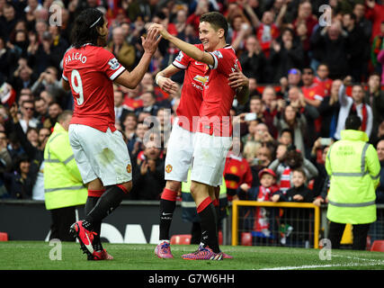 Manchester United's Ander Herrera celebrates scoring his side's third goal of the game with Angel Di Maria (back) and Radamel Falcao during the Barclays Premier League match at Old Trafford, Manchester. PRESS ASSOCIATION Photo. Picture date: Saturday April 4, 2015. See PA story SOCCER Man Utd. Photo credit should read: Martin Rickett/PA Wire. Stock Photo