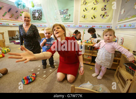 First Minister Nicola Sturgeon tries to catch a ball with 18 month old Patrick McVey and two year old Kara Morris watched by headteacher Irene Hogg during a visit to Loanhead after-school club and community nursery while on the General Election campaign trail. Stock Photo