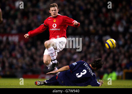 Soccer - FA Barclays Premiership - Manchester United v Portsmouth - Old Trafford. Portsmouth's Dejan Stefanovic slides in on Manchester United's Wayne Rooney Stock Photo