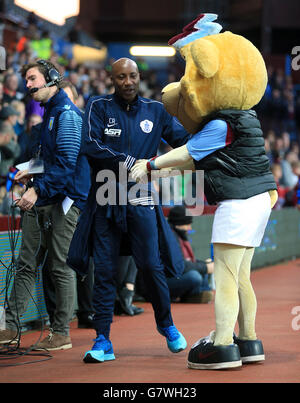 Queens Park Rangers manager Chris Ramsey is greeted by the Aston Villa mascot Bella the Lion before the game Stock Photo