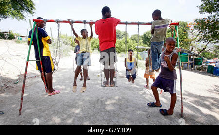 June 27, 2016 - Port-Au-Prince, Florida, U.S. - 061110 (Lannis Waters/The Palm Beach Post) P0ORT-AU-PRINCE, HAITI - Kids play on a swinset in a play area set up at the Golf Club refugee camp, on the grounds of the Petionville Club. An estimated 20,000 people are living in the camp; 25,000 before 5,000 were relocated to the Corail camp outside of Port-au-Prince. SCR 2774 (Credit Image: © Lannis Waters/The Palm Beach Post via ZUMA Wire) Stock Photo