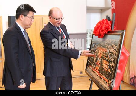 Edinburgh, Britain. 27th June, 2016. Zhang Huazhong (L), Chinese Deputy Consul General in Edinburgh, and Edinburgh Tattoo chief executive and producer Brigadier David Allfrey talk about a picture at the Beijing tourism photo show in Edinburgh, Britain, on June 27, 2016. A grand photo show was held on Monday inside the famous tourist attraction of Edinburgh Castle to promote Beijing tourism resources, attract tourists and enhance cultural exchanges. © Guo Chunju/Xinhua/Alamy Live News Stock Photo