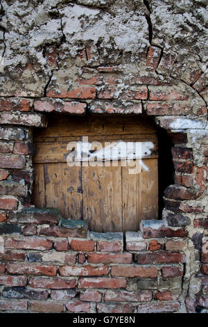 Wooden boards, a hole in a brick wall Stock Photo