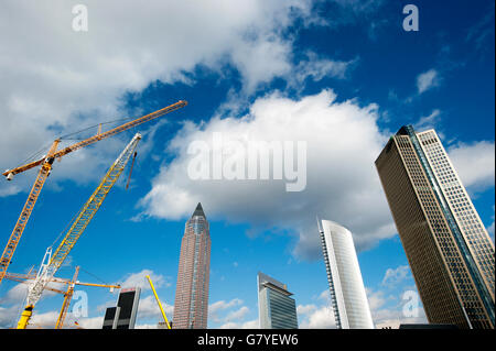 Construction cranes standing next to high-rise buildings, from left, Messeturm tower, the twin towers Castor and Pollux and Stock Photo