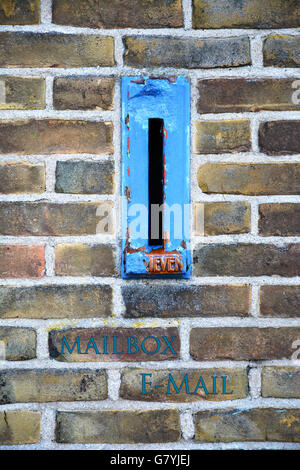 Close up of old blue mailbox in a bricks wall Stock Photo