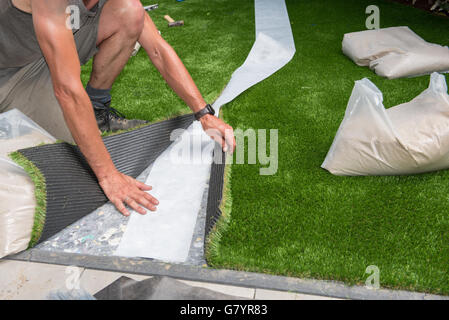 professional gardener is cutting artificial turf to fit Stock Photo